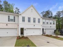 Charming townhome exterior with white brick, attached garage, and well-manicured landscaping at 1604 Ruskin Way, Marietta, GA 30062