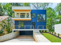 Modern home showcasing a striking blue exterior with a balcony and a well-manicured front yard at 237 Altoona Sw Pl, Atlanta, GA 30314