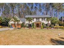 Charming home with a well-kept lawn, mature landscaping, and a welcoming front porch at 4970 Lakeland Woods Ct, Atlanta, GA 30338
