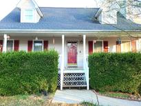 Charming home with a red front door, complemented by lush greenery and manicured hedges at 345 Lambeth Dr, Hiram, GA 30141