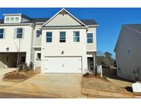 Charming two-story home with a two-car garage and pristine white brick exterior under a bright blue sky at 1337 Fern Ridge Ct # 28, Norcross, GA 30093