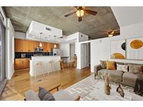 Bright living room featuring a modern kitchen, hardwood floors, and comfortable seating area with modern decor at 44 Peachtree Nw Pl # 1328, Atlanta, GA 30309