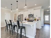 Modern kitchen boasts a quartz countertop island with pendant lighting and stainless steel appliances at 4527 Moray Dr, Mableton, GA 30126