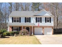 Charming two-story home with a brick foundation, attached two-car garage, and manicured front yard at 5770 Millstone Dr, Cumming, GA 30028