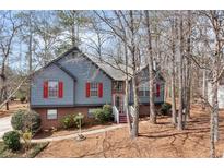 Charming two-story home featuring red shutters, a brick foundation, and a landscaped front yard at 5073 Hyacinth Ln, Austell, GA 30106