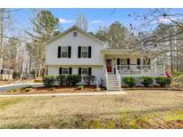 Charming two-story home featuring a front porch, landscaped yard and classic white siding at 673 Waters Rd, Hiram, GA 30141