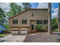Charming two-story home featuring a two-car garage, inviting front porch, and manicured landscaping at 3260 Sims View Ct, Snellville, GA 30078