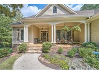 Inviting front porch with stone details and comfortable seating, perfect for relaxing outdoors at 3270 New University Trl, Cumming, GA 30041