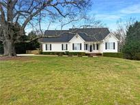 Charming single-Gathering home with black shutters, mature trees, and well-manicured lawn on a sunny day at 45 Fiddle Crk, Social Circle, GA 30025