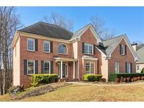 Charming brick two-story home with a well-manicured lawn and mature landscaping at 918 Edgewater Dr, Loganville, GA 30052