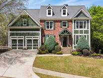 Charming two-story home with a brick facade, green trim, dormer windows, and a well-manicured front yard at 102 Stargaze Rdg, Canton, GA 30114