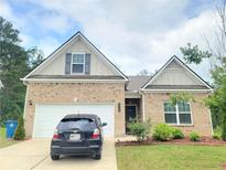 Charming brick home featuring a two-car garage, well-kept lawn, and inviting curb appeal at 1125 Campbell Pine Trl, Lawrenceville, GA 30045