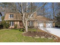 Charming brick home with a well-manicured lawn, attached garage, and mature landscaping at 1135 Banbury Cross, Avondale Estates, GA 30002