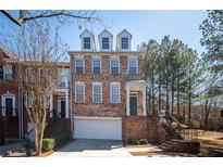 Charming brick townhome with a two-car garage and inviting curb appeal at 402 Iona Abbey Se Ct, Smyrna, GA 30082