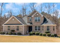 Charming traditional home with brick facade, manicured lawn and mature landscaping at 7881 Wilkerson Ln, Palmetto, GA 30268