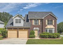 Charming two-story brick home with a manicured lawn, attached two-car garage, and welcoming curb appeal at 3370 Flagstone Trce, Ellenwood, GA 30294