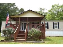 Charming single Gathering home with covered front porch and flower beds in the front yard at 59 Pine Ridge Ln, White, GA 30184