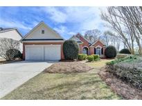 Charming brick home with a two-car garage and well-manicured landscaping at 3535 Southmont Ct, Cumming, GA 30041