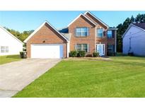 Charming two-story brick home with well-maintained lawn and attached garage at 6251 Lamp Post Pl, Atlanta, GA 30349