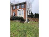 Charming brick townhome featuring a bay window and well-maintained front yard at 1672 Cedar Bluff Way, Marietta, GA 30062