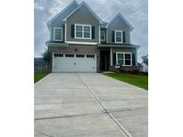 Charming two-story home featuring a two-car garage, brick accents, and well-manicured lawn at 11102 Suria Dr, Covington, GA 30014