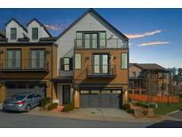 Charming townhouse with a two-car garage, balconies, and manicured landscaping at 551 Verismo Way, Alpharetta, GA 30009
