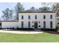 Stunning two-story home with white painted brick, black trim, and a lush green lawn at 3034 Farmington Se Dr, Atlanta, GA 30339