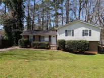 Charming split-level home with a well-maintained lawn and mature trees at 8271 Walnut Dr, Jonesboro, GA 30238