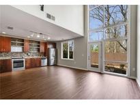 Bright living space with hardwood floors, kitchen view, and large windows showcasing the outdoor view at 1342 Rietveld Nw Row, Atlanta, GA 30318