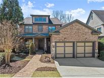 Charming brick home with a two-car garage, landscaped front yard, and inviting entryway at 3405 Camellia Ln, Suwanee, GA 30024