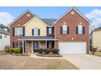 Traditional two-story home with brick and siding, black shutters, and an attached two-car garage at 907 Hindman Pl, Mcdonough, GA 30253