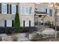 Charming brick townhome featuring a welcoming entrance with iron railings and manicured landscaping at 226 Chastain Preserve Ne Ln, Atlanta, GA 30342