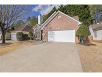 Charming brick home featuring a two-car garage and a well-maintained front yard and extra parking at 2461 Lakebrooke Dr, Marietta, GA 30066