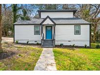 Charming home featuring a new roof, fresh paint, a vibrant blue front door, and a well-manicured lawn at 658 Woods Dr, Atlanta, GA 30318