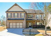 Charming two-story home featuring a brick and stone facade, attached two-car garage, and manicured lawn at 3129 Arbor Oaks Dr, Snellville, GA 30039