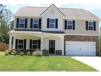 Charming two-story home with a well-manicured lawn and a cozy front porch with stone accents at 83 Nyishol Way, Dallas, GA 30157