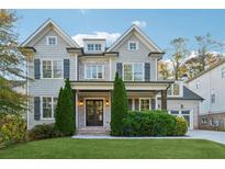 Charming two-story home with a manicured lawn, gray shingles, a brick facade, and a welcoming front porch at 4333 Rickenbacker Ne Way, Atlanta, GA 30342