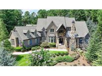 Stately stone and shingle home with manicured landscaping and charming blue shutters at 829 Big Horn Holw, Suwanee, GA 30024