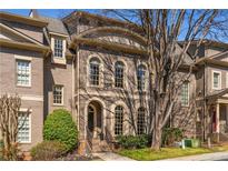 Elegant brick home with arched windows and a well-maintained front yard, showing classic architectural details at 2009 Kensington Green Se Dr, Smyrna, GA 30080