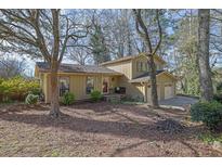 Charming home with a red door, lush landscaping, and a welcoming front porch at 4570 Nantucket Sw Dr, Lilburn, GA 30047