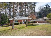 Charming single-story brick home with a well-maintained lawn and convenient carport at 2251 Trailwood Se Dr, Smyrna, GA 30080
