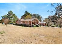 Charming brick ranch-style home featuring a well-maintained lawn and mature trees at 2297 Hylaea Rd, Tucker, GA 30084
