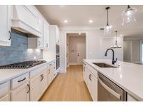 Bright kitchen boasts white cabinets, stainless appliances, and quartz counters, perfect for modern living at 108 Redford Ln, Canton, GA 30115