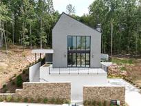 Stunning modern home with gray siding, large windows, and a stone retaining wall at 1171 Lupo Loop, Chattahoochee Hills, GA 30268