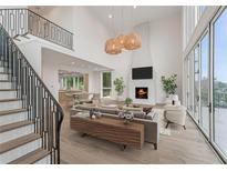 Bright living room features a fireplace, high ceilings, and large windows offering plenty of natural light at 1171 Lupo Loop, Chattahoochee Hills, GA 30268