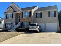 Charming two-story home with stone accents, a well-manicured lawn, and attached two-car garage at 252 Berkley Dr, Villa Rica, GA 30180