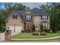 Charming two-story home boasts a manicured front lawn and well-maintained landscaping with a two car garage at 85 Providence Pkwy, Covington, GA 30014