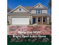 Charming two-story brick home featuring a welcoming front porch, two-car garage, and professionally landscaped yard at 1236 Maston Rd, Auburn, GA 30011