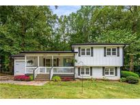 Charming home featuring a welcoming front porch, beautiful landscaping, and a well-maintained lawn at 2653 Hatfield Se Cir, Atlanta, GA 30316