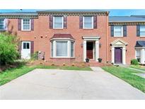 Charming brick townhome featuring a bay window, manicured lawn, and ample parking space at 315 Towergate Pl, Atlanta, GA 30350